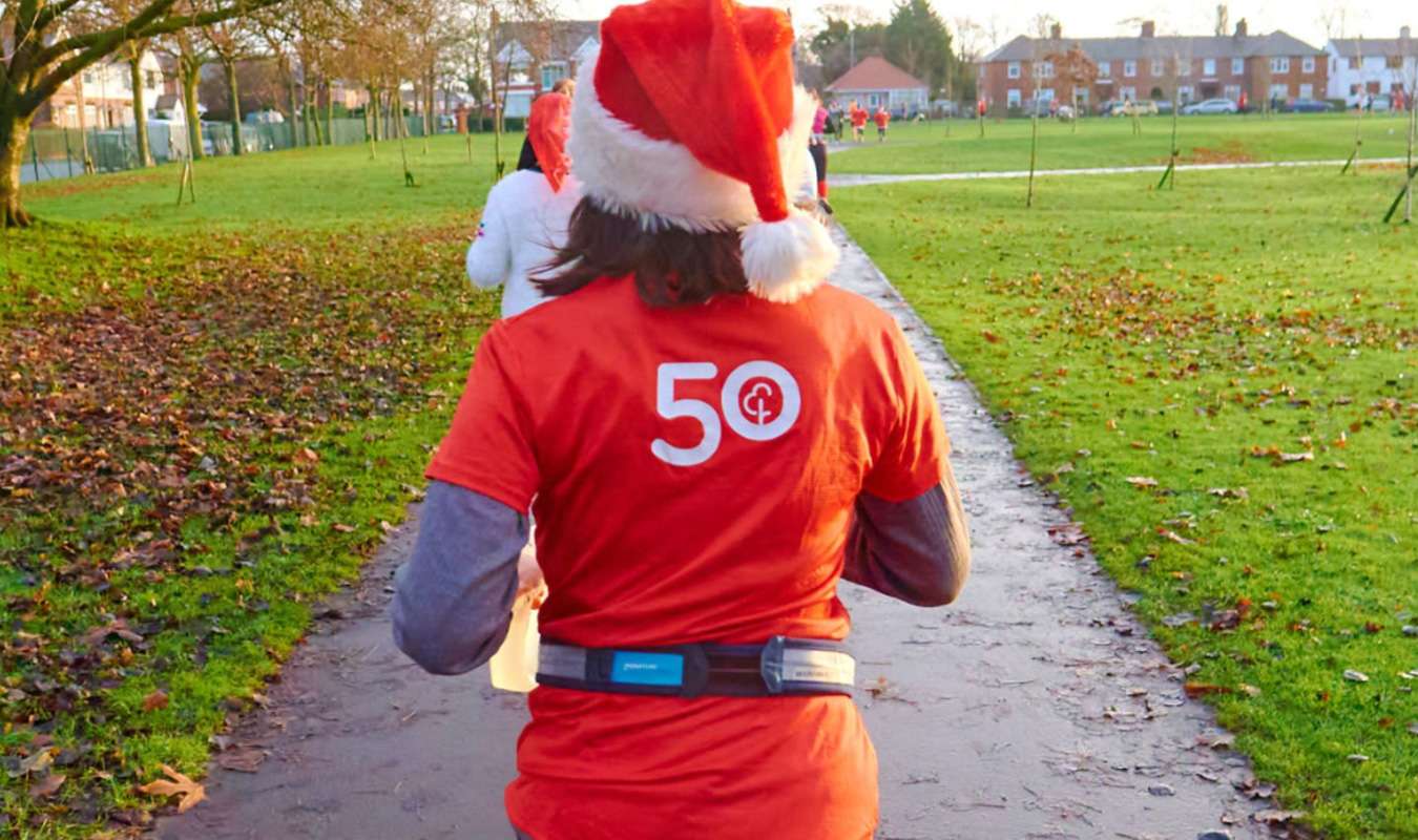 Back of woman with red santa hat jogging