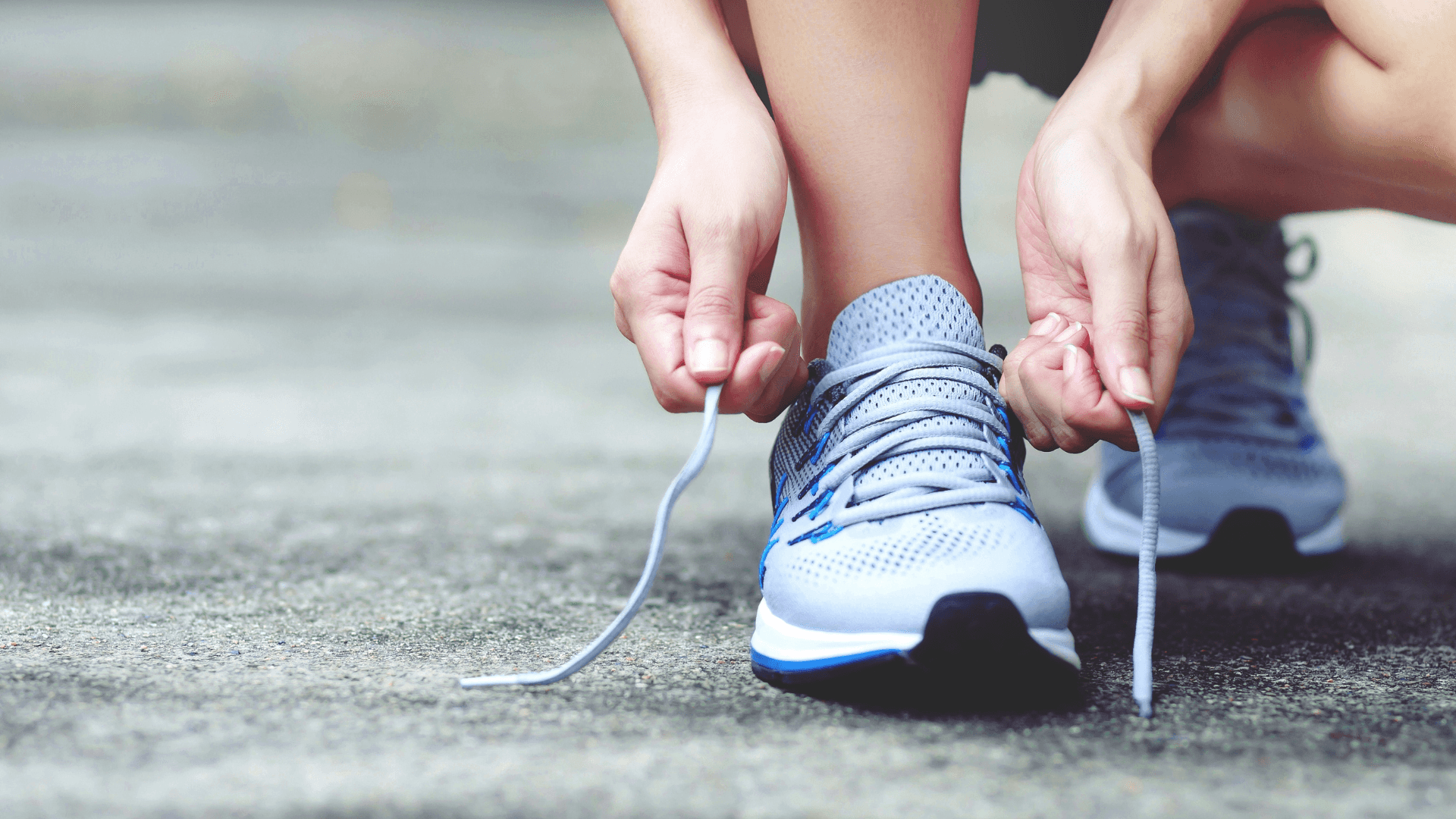 woman putting on blue running shoes